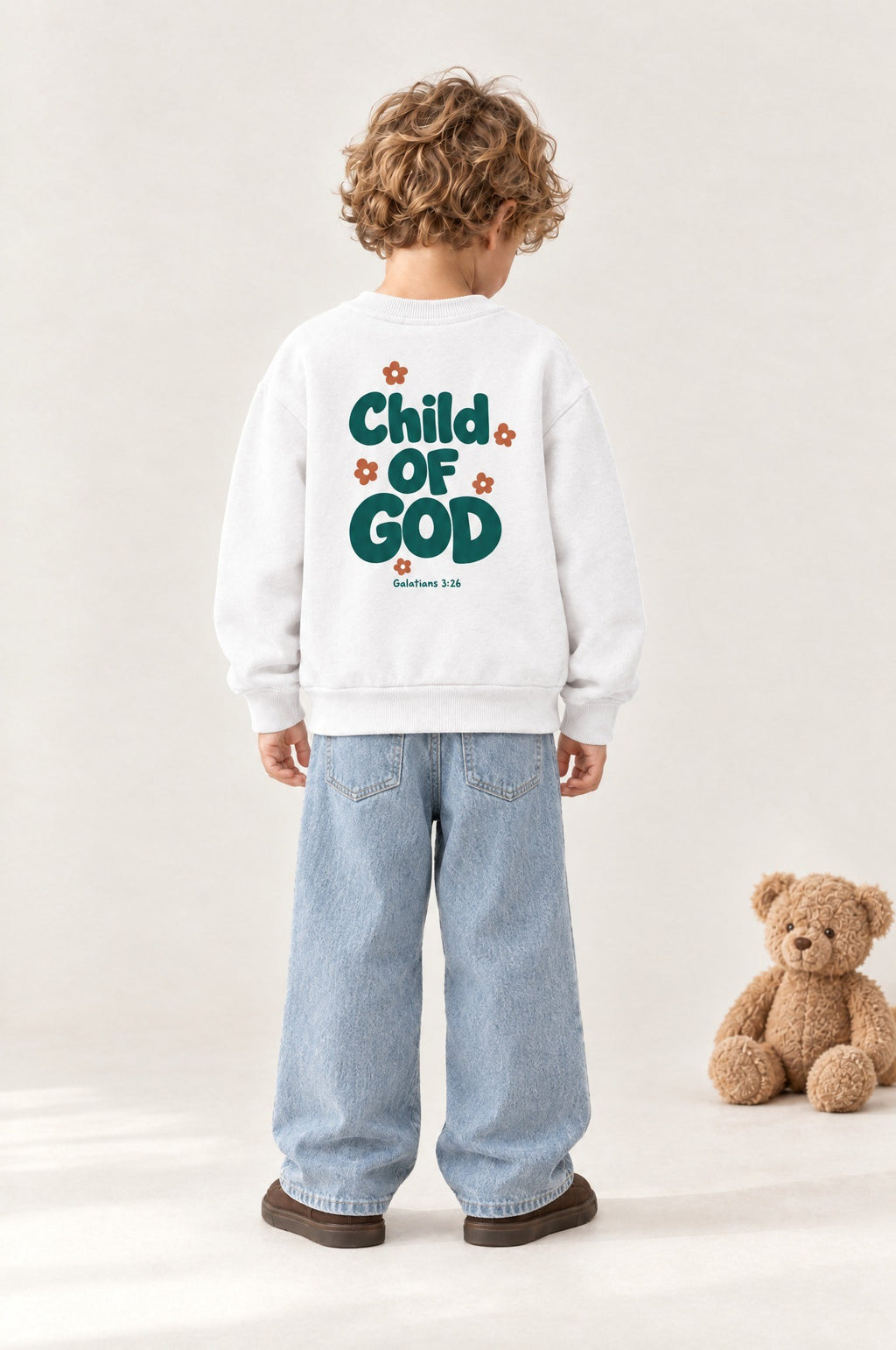 Kind von hinten im Kinder-Sweater „Child of God (Grün)“ in Weiß