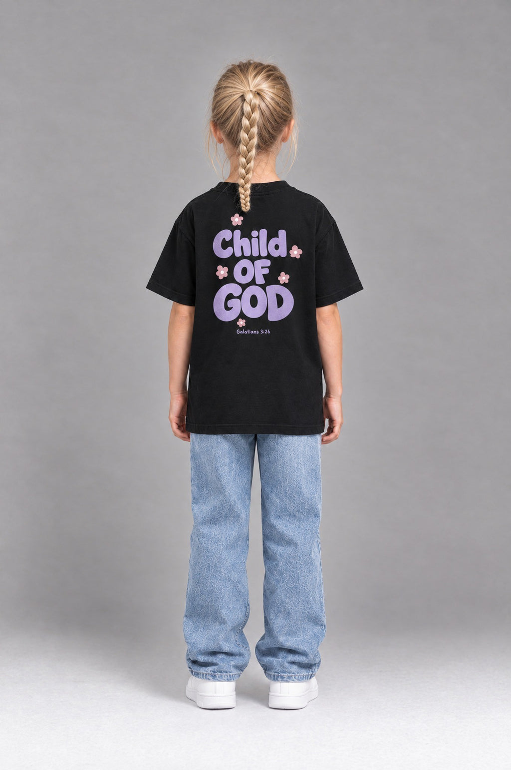Kind trägt das schwarze Kinder T-Shirt „Child of God“ mit lila Druck von Little Faith