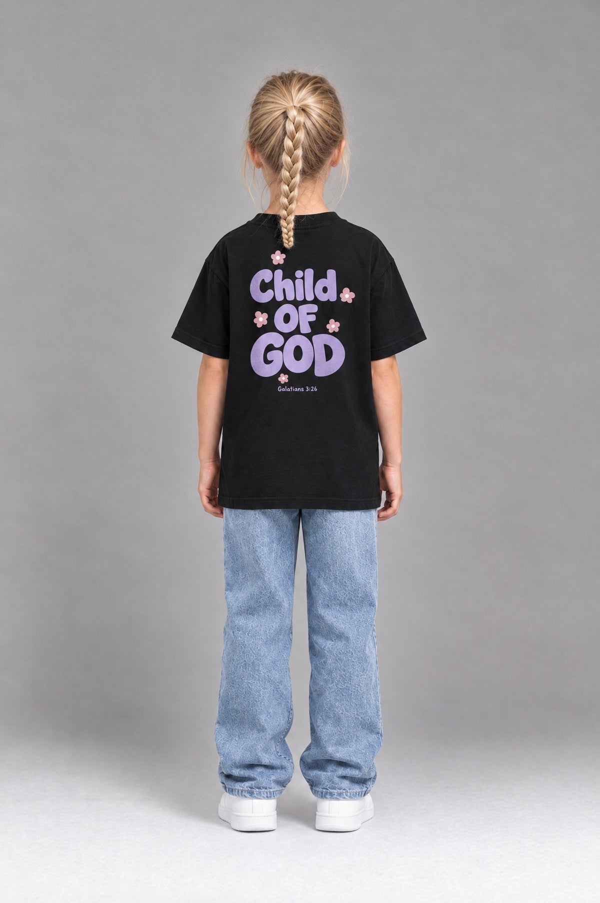 Kind trägt das schwarze Kinder T-Shirt „Child of God“ mit lila Druck von Little Faith