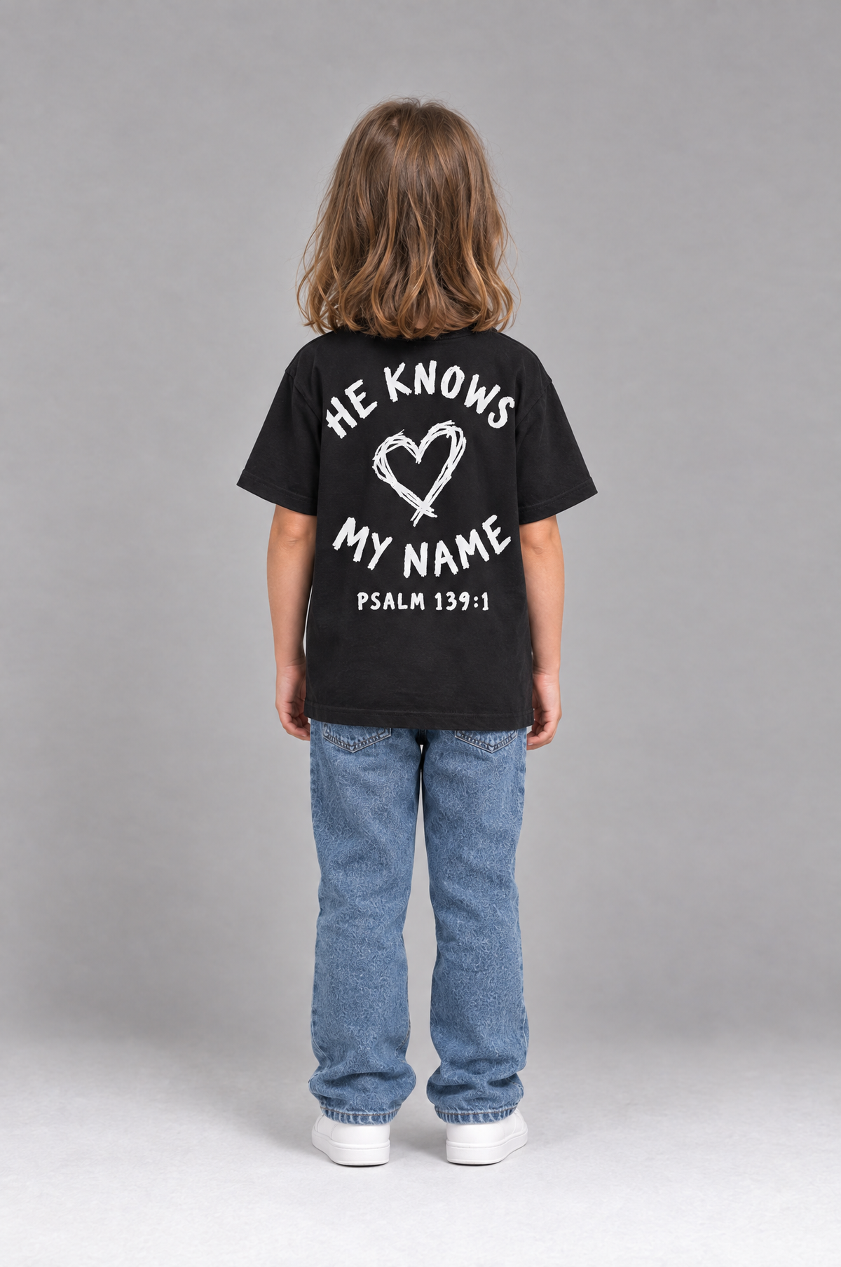 Kind trägt das schwarze Kinder T-Shirt „He knows my name (Heart)“ von Little Faith