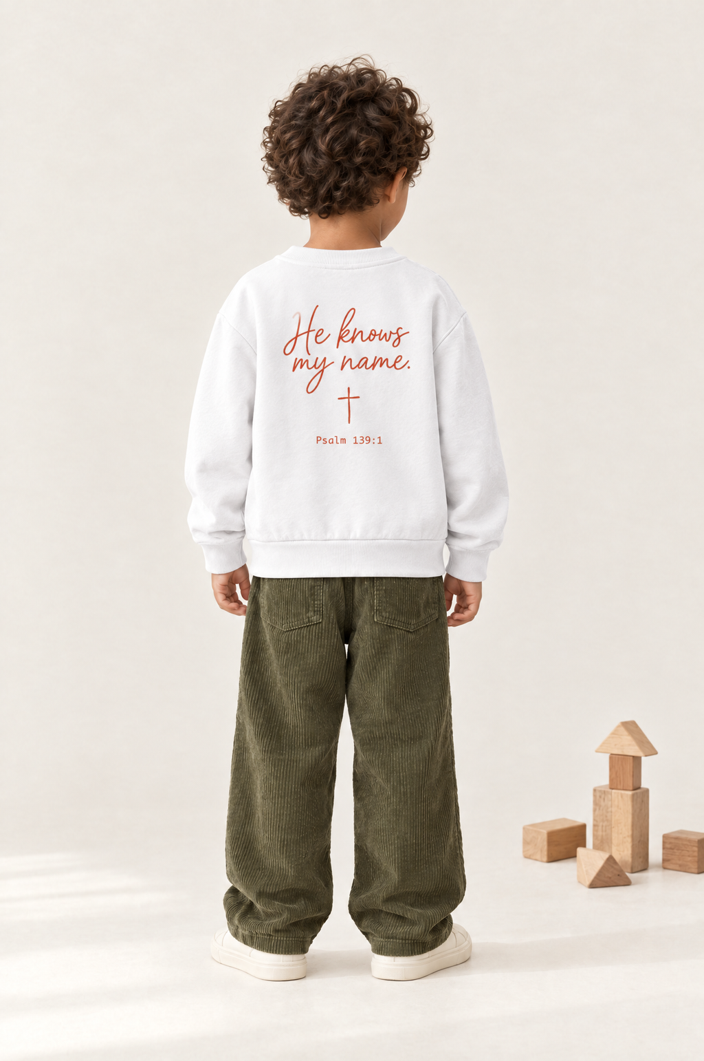 Kind von hinten im Kinder-Sweater He knows my name in Weiß