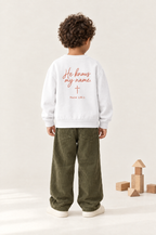 Kind von hinten im Kinder-Sweater He knows my name in Weiß