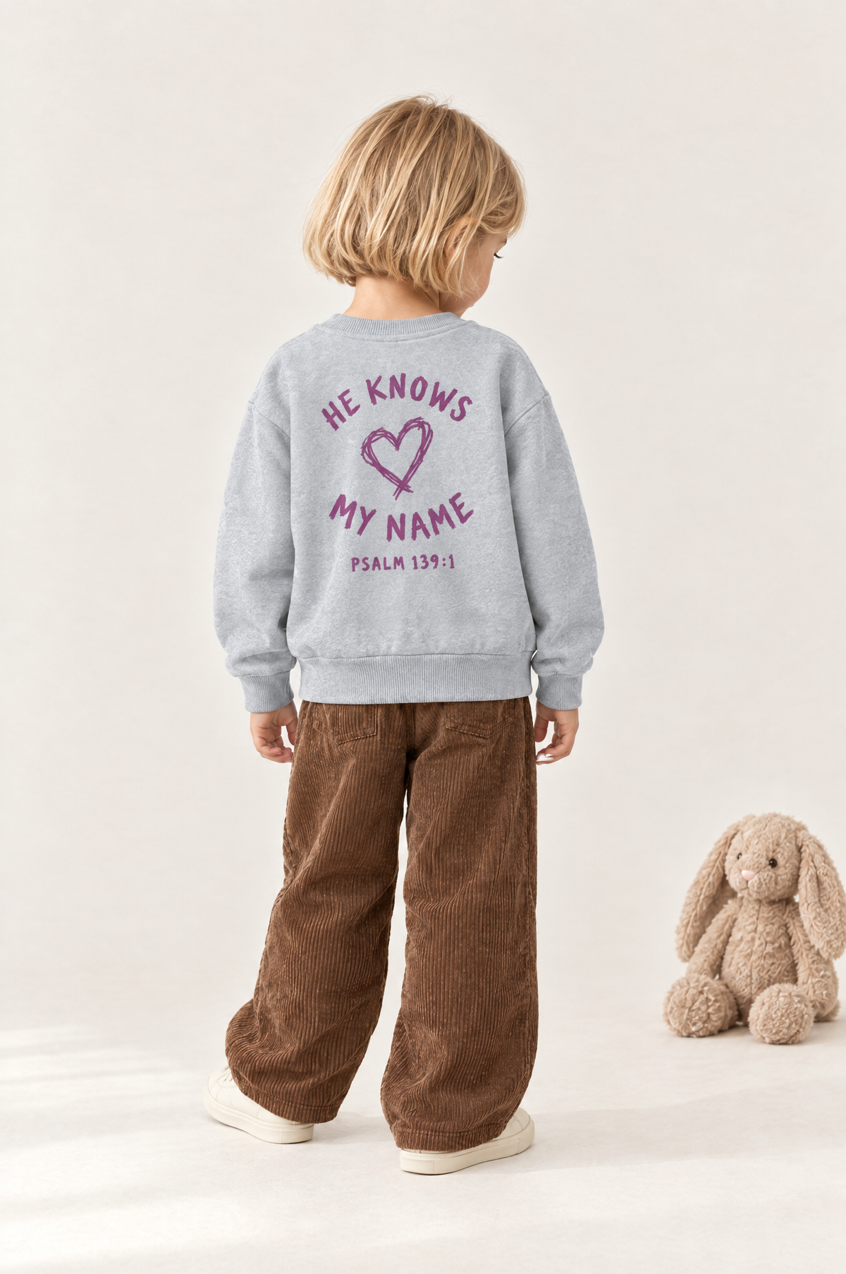 Kind von hinten im Kinder-Sweater He knows my name (Heart) in Grau meliert