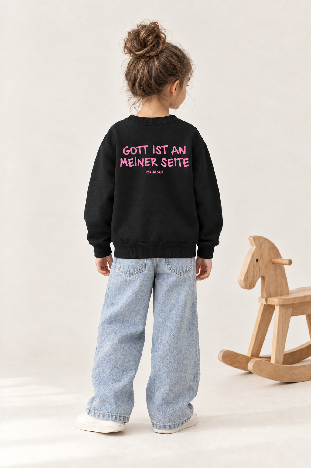 Kind von hinten im Kinder-Sweater Gott ist an meiner Seite in Schwarz